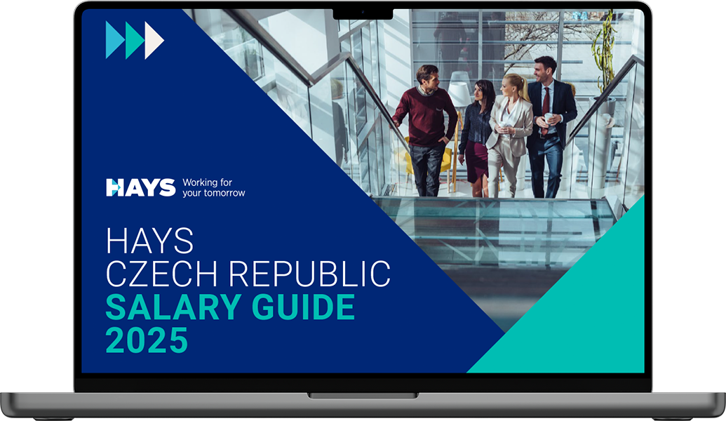 A laptop screen displays the “Hays Czech Republic Salary Guide 2025” with vibrant colors and smiling professionals.